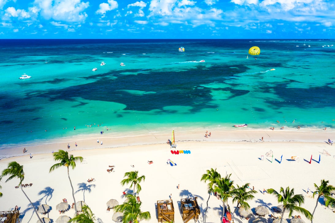 Aerial view of Bavaro beach Punta Cana tropical resort in Dominican Republic. Beautiful atlantic tropical beach with palms, umbrellas and parasailing balloon